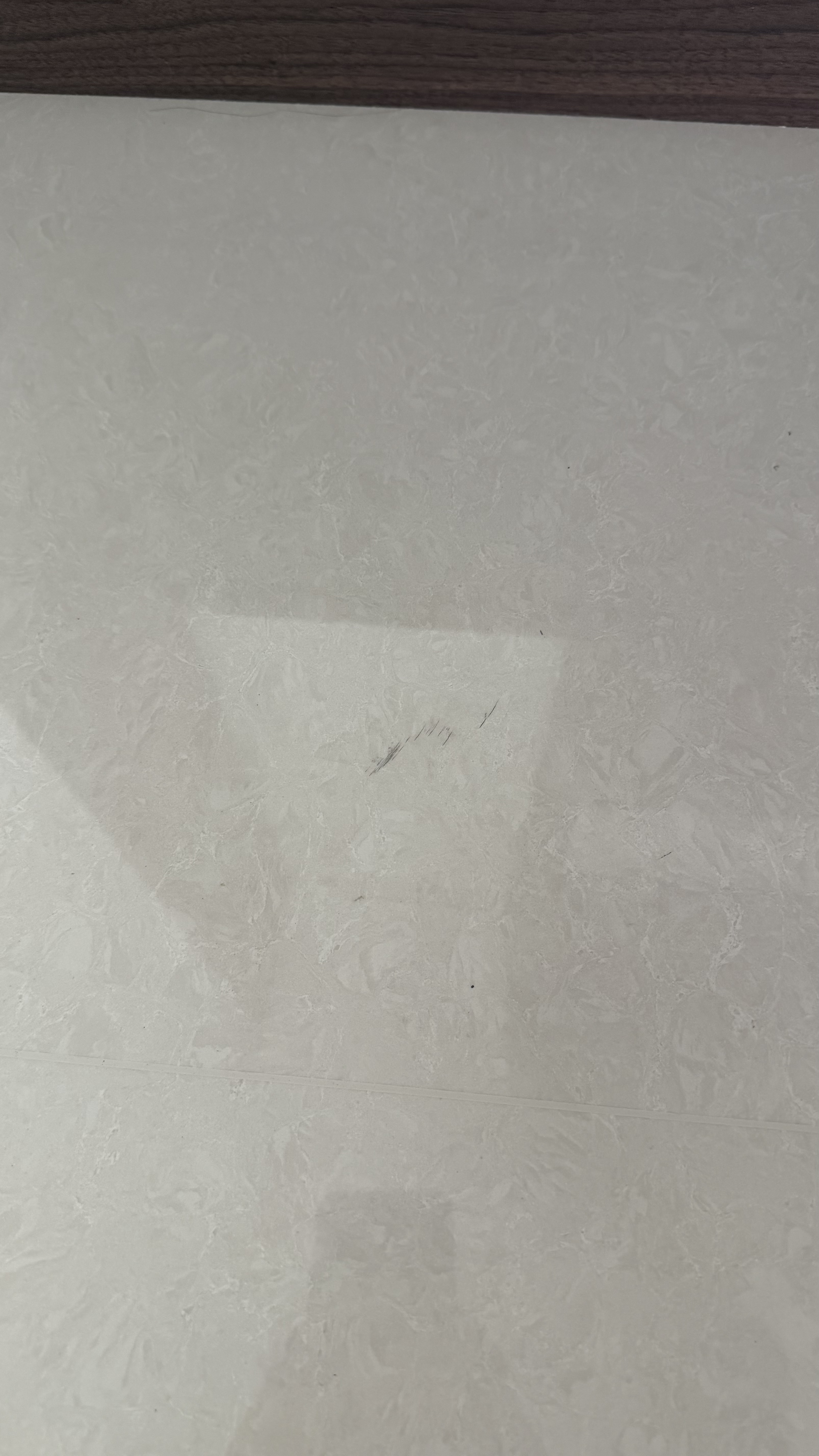 Floor Tile Scratch Repair — Before: Visible dark scratches on the floor tile.