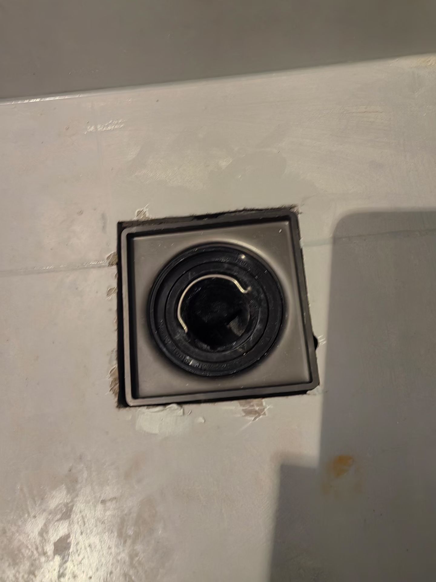 Floor Drain Surround Repair — Before: Damaged surface edges around a floor drain before repair.