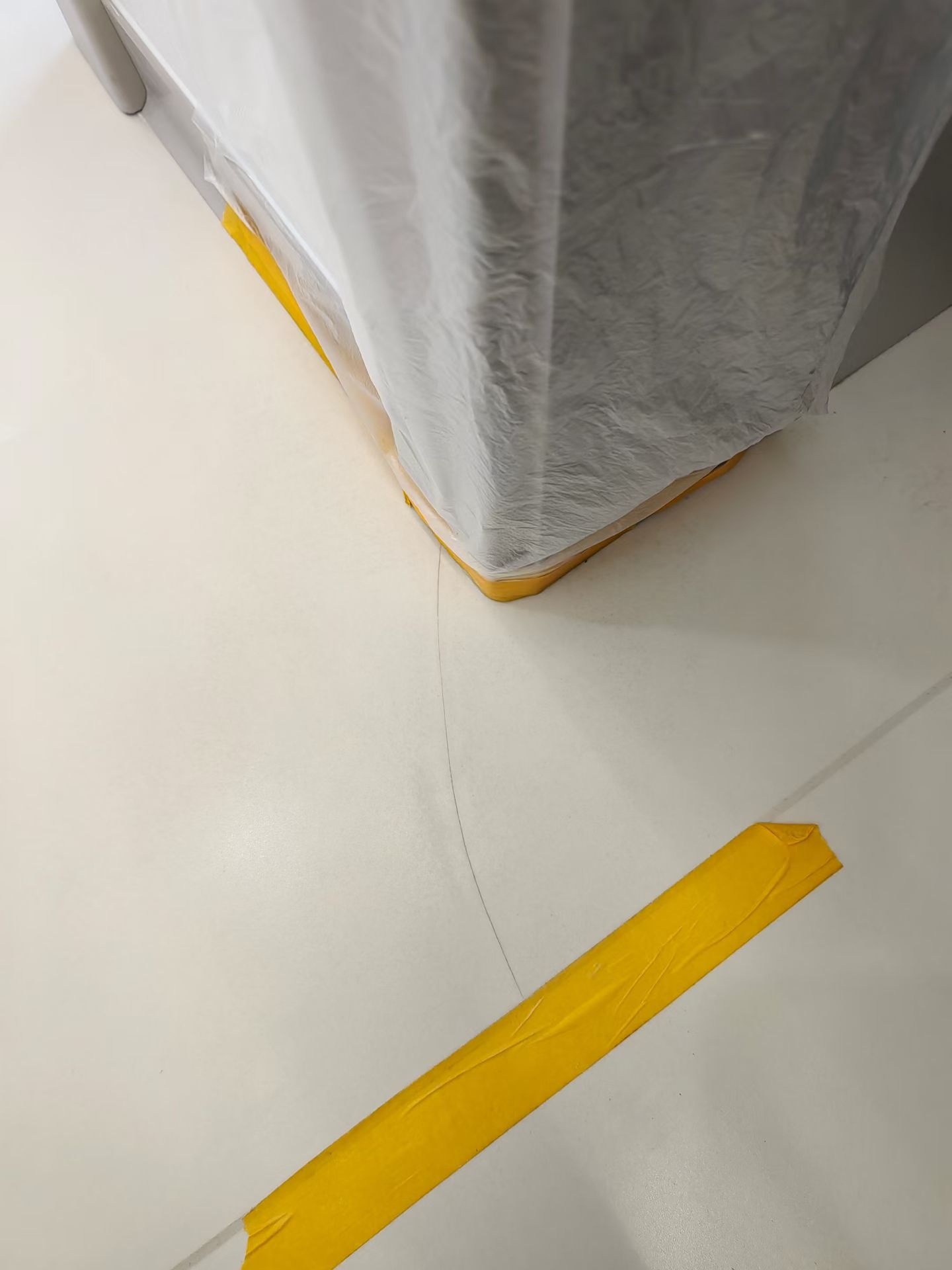Pale Floor Surface Crack Repair — Before: A visible crack in the pale floor surface near the column.