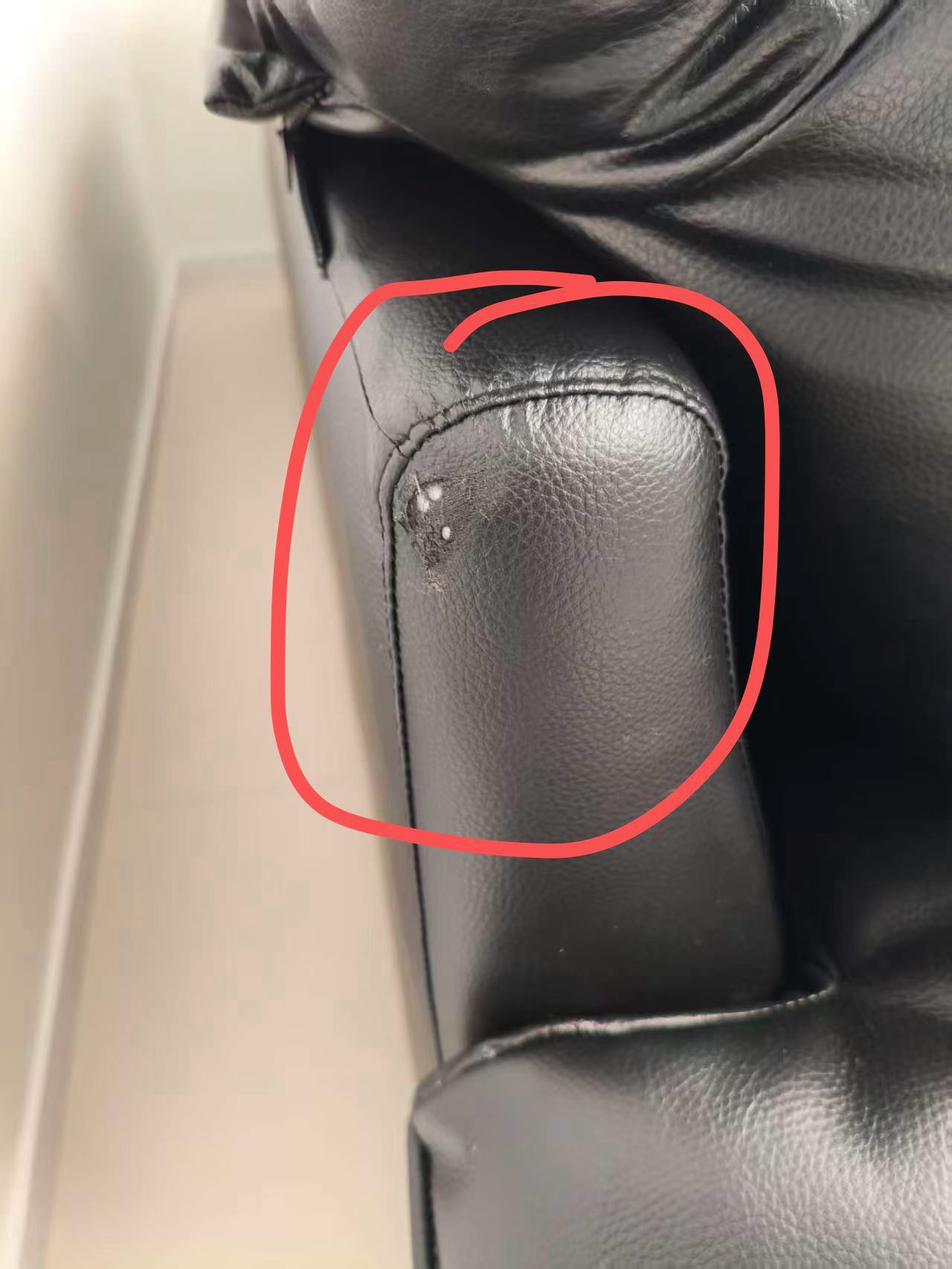 Black Leather Sofa Armrest Repair — Before: Damage on a black leather sofa armrest before repair.