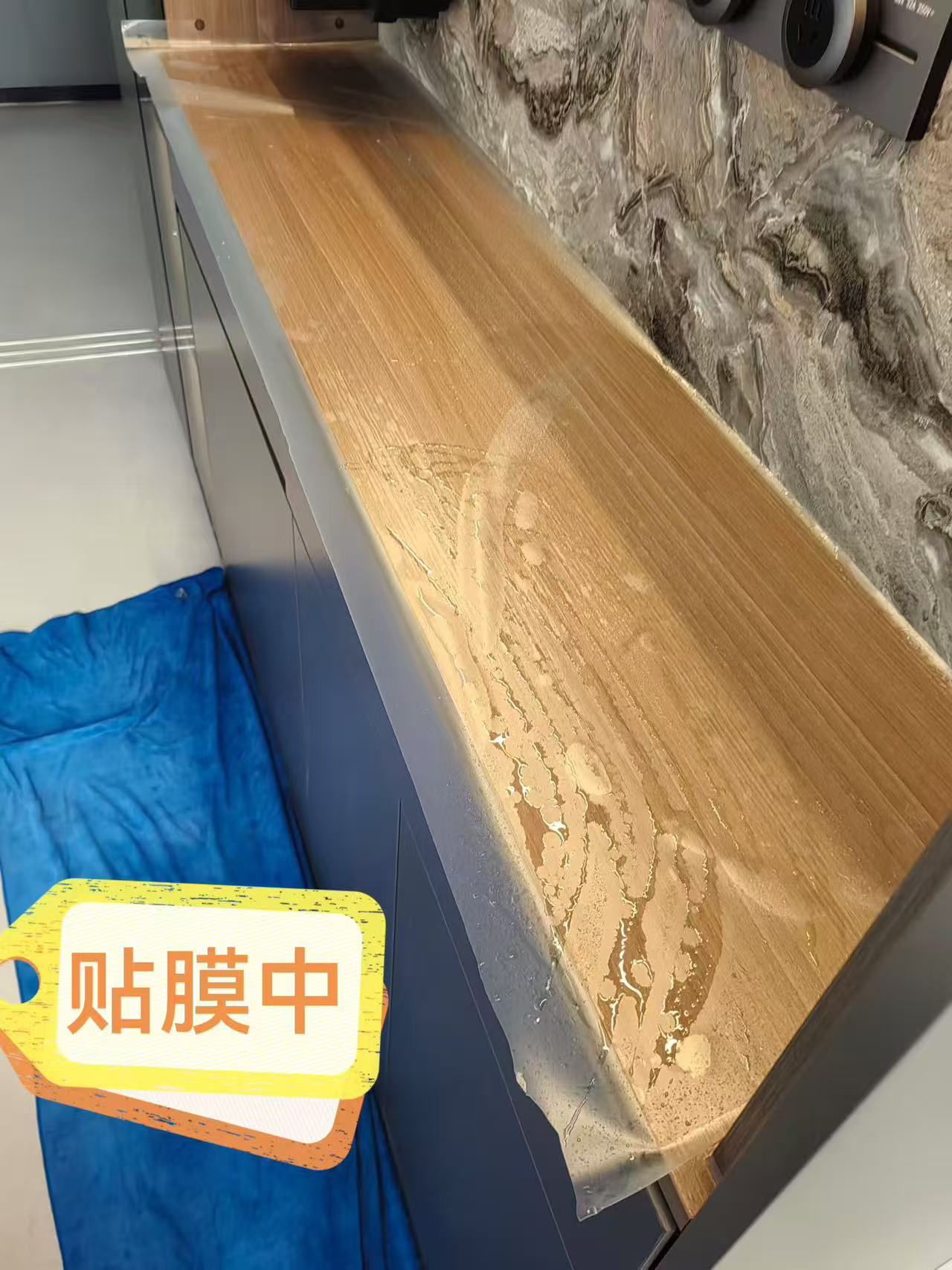 Marble Protection - Photo 11 — Project Photo: Wooden counter during protective film installation.