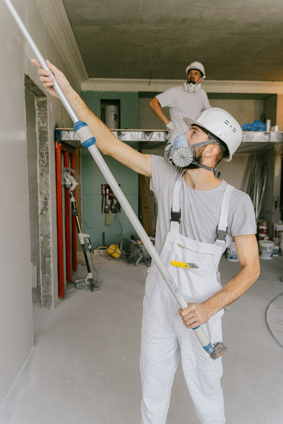 Workers preparing and finishing an interior wall during renovation — illustrative stock photo