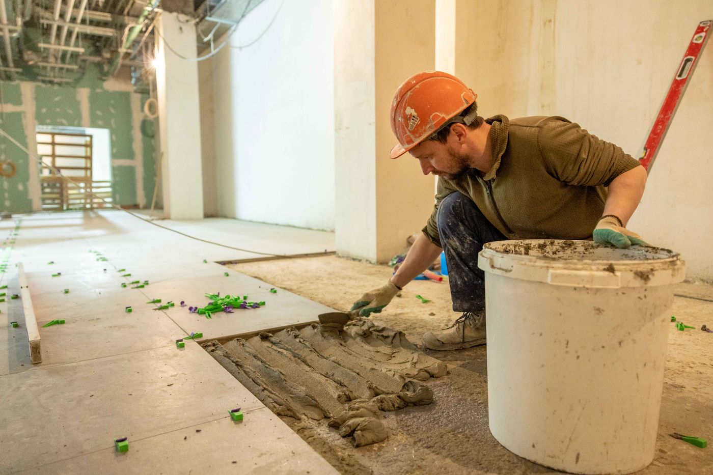 Worker preparing and laying tiles during renovation